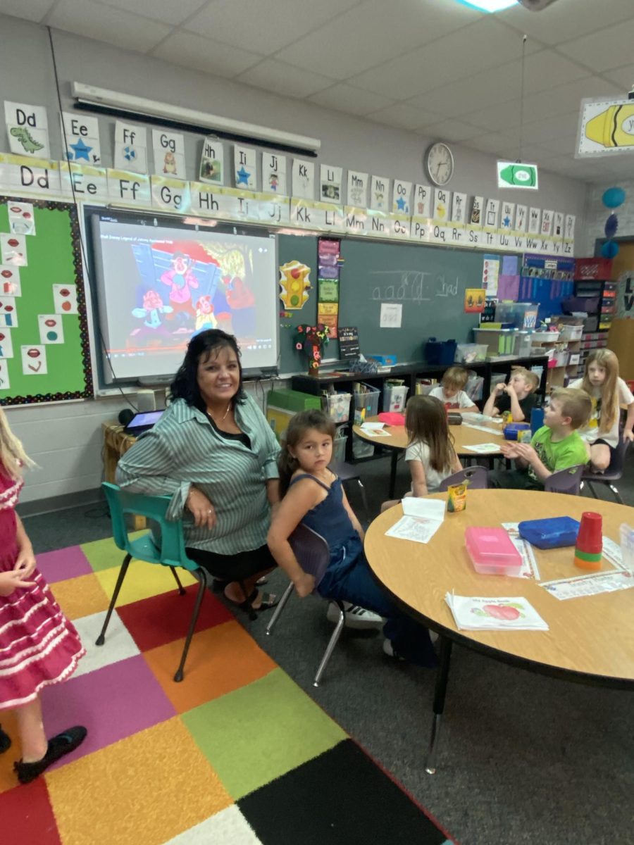 Mrs. Pauly smiling with one of her students.